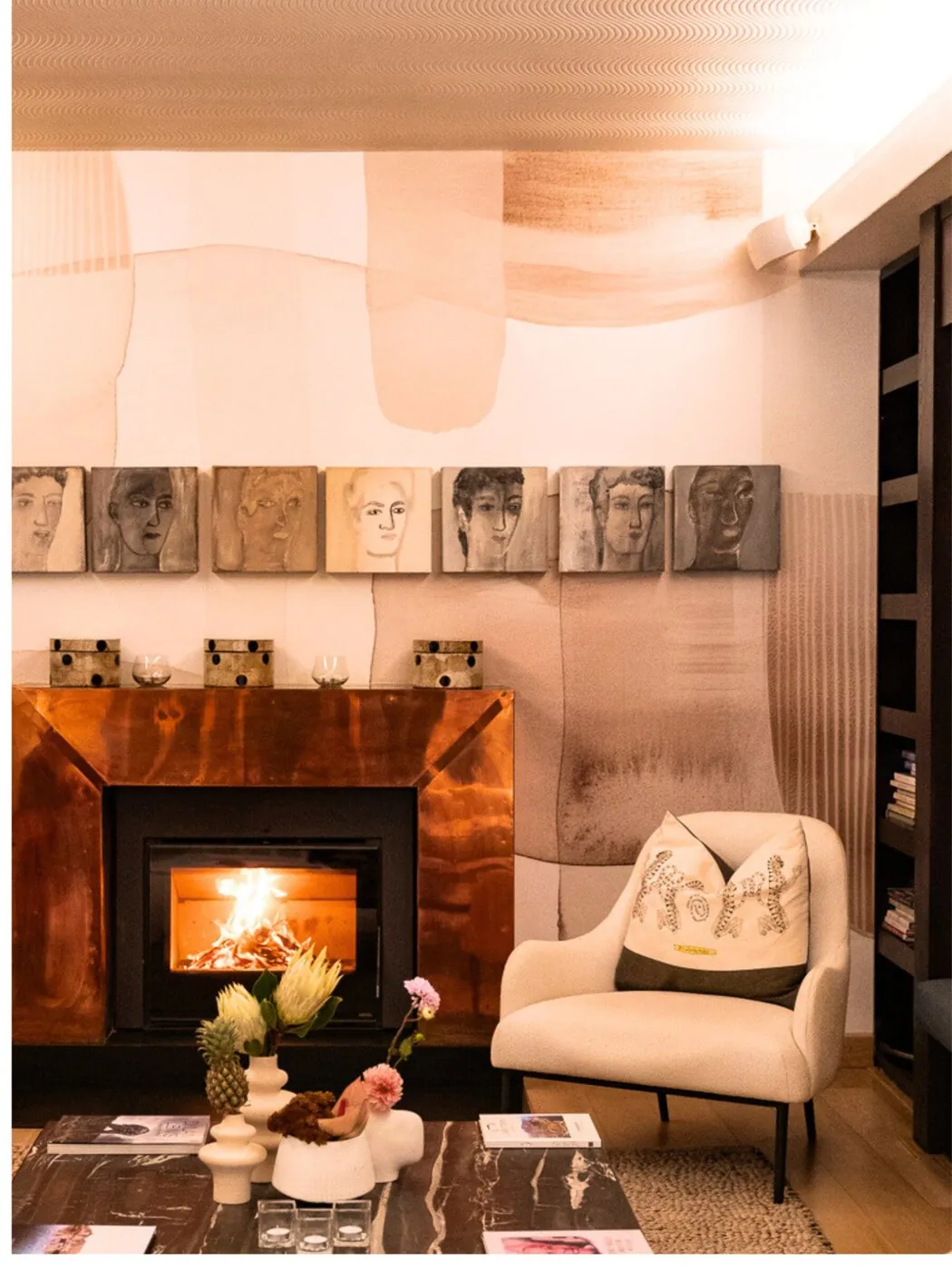 Lounge with fireplace and portrait artworks